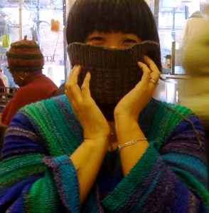 Fiber friend hiding beneath cowl in Noro sweater at LYS (The Point NYC)
